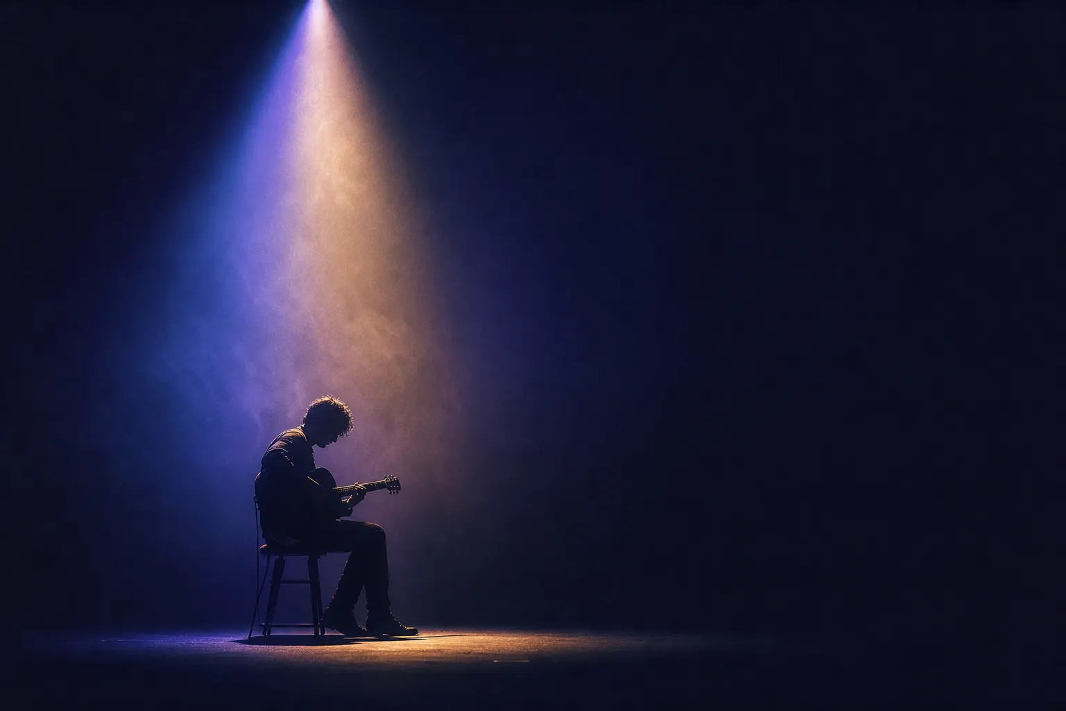 A lone musician on a dark stage under a single soft spotlight